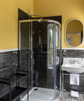 A yellow bathroom with black tiles.