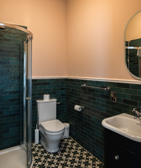 A bathroom with blue tiles and yellow walls.