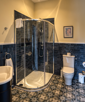 A bathroom with blue tiles and yellow walls.
