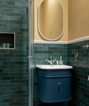 A bathroom with blue tiles and yellow walls.