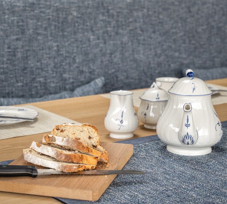 Close up of a kitchen table with bread on a cutting board.