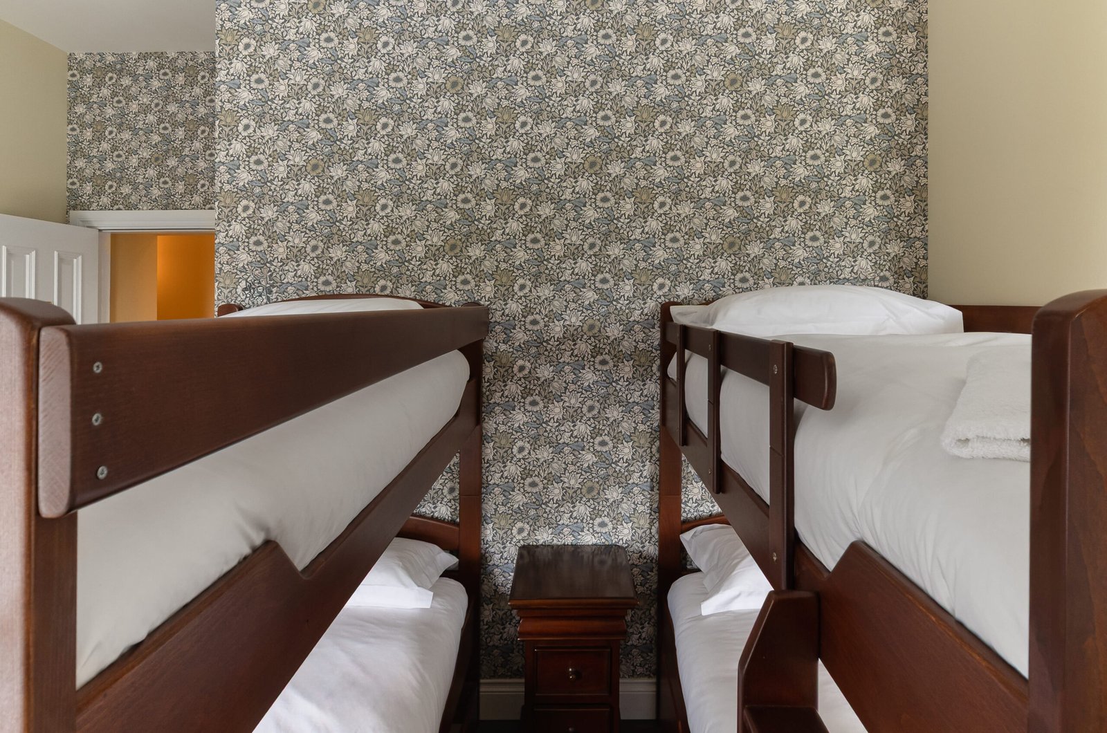 A yellow bedroom with two bunk bed and a patterned wall.