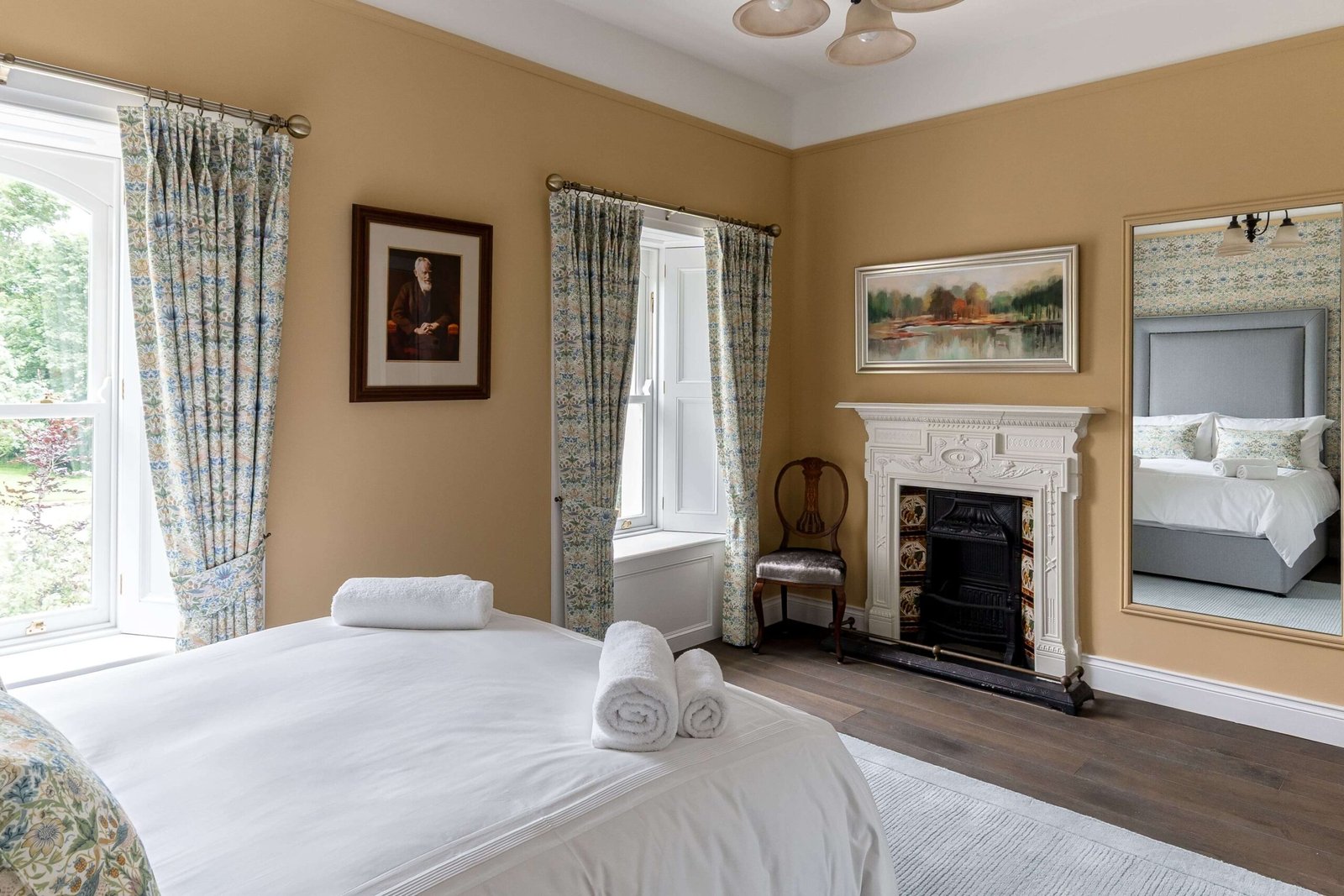 A yellow bedroom with a double bed and a fireplace.