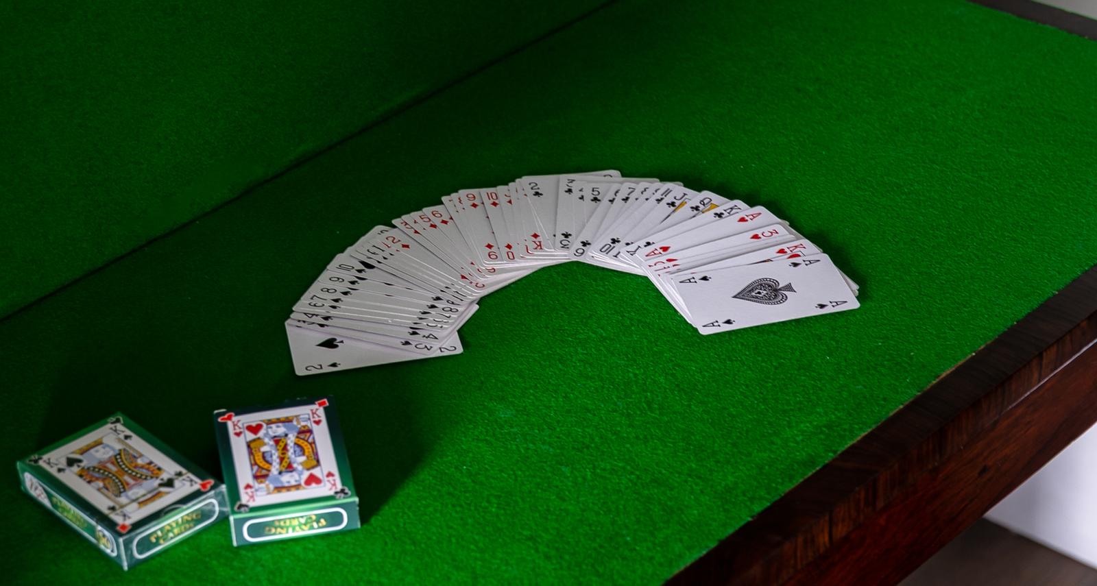 Playing cards on a green surface.