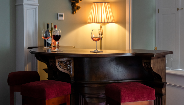 A close up of a small bar with wines on top of it.